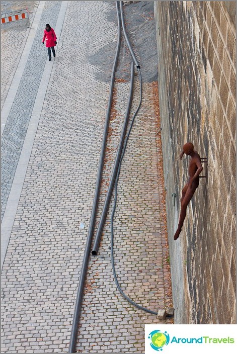 Terraplén del río Moldava y escultura inusual en la pared