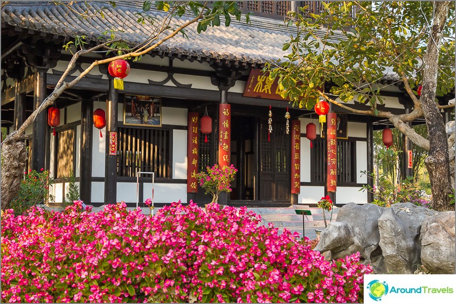 Chinese building surrounded by stones and bonsai