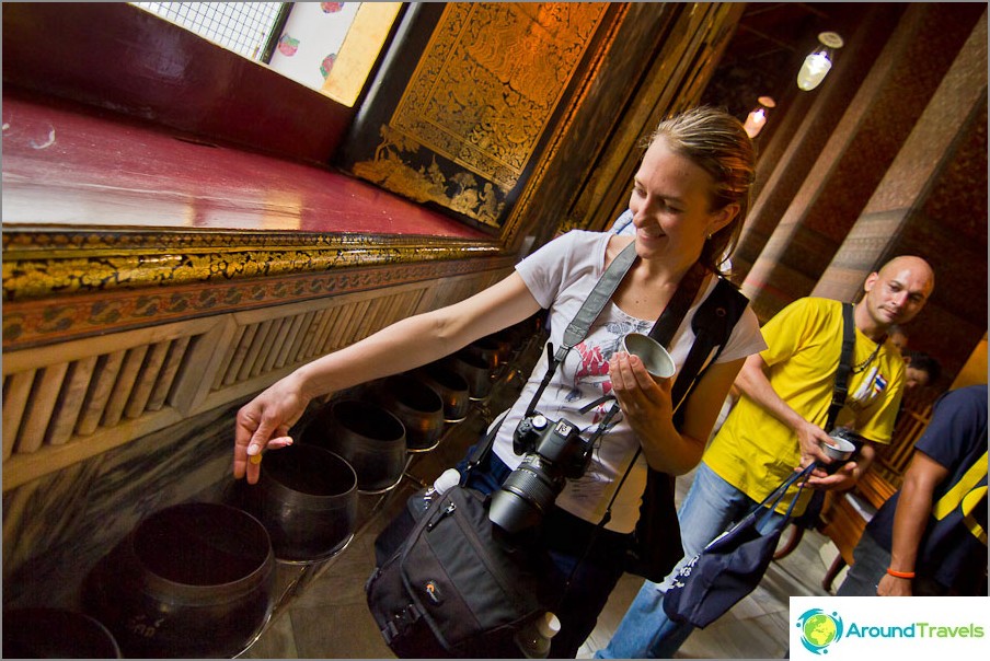 Throwing coins for luck in the Temple of the Reclining Buddha