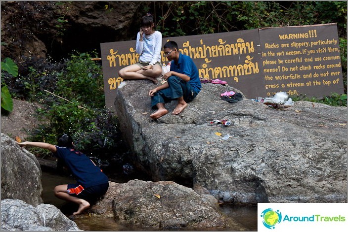 Locals have a rest near the waterfall